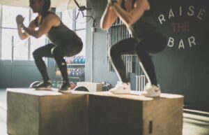 Two people squatting on a box